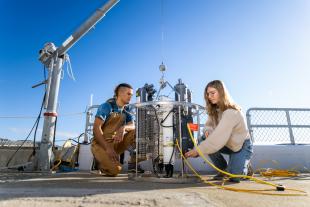 Fellowship winner Jake Roth, left, and another student prep to deploy a seawater collection device in the waters off the Cal Poly Pier. 