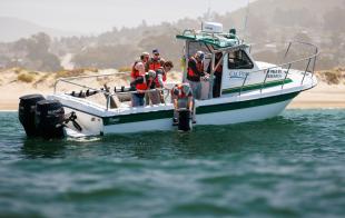 Cal Poly students launch an ocean powered generator from a boat in Morro Bay.