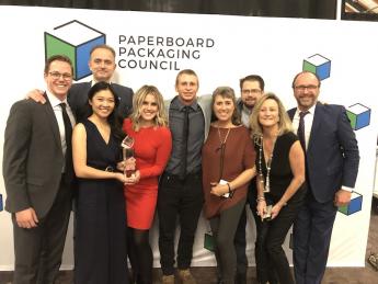 Cal Poly students and faculty pose with a trophy after a packaging competition.