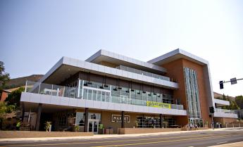 A brand new dining complex, with three tiered levels, enclosed in glass and brick, sets against a hillside in the afternoon sun