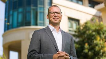 Dean Fleming stands in front of Cal Poly's business building