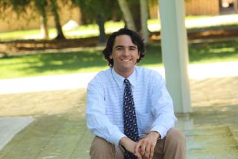 The newest Panetta intern wears a blue button-down and khaki pants as he smiles for a professional photo.