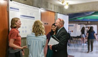 Dean Wendt of the College of Science and Mathematics speaks with students at an event.