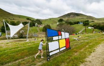 A student wheels a project into the 2024 Design Village