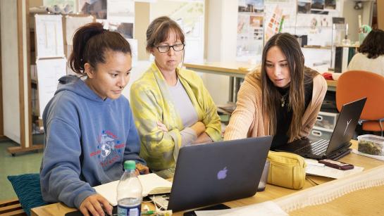 Prof Stacy White working with two students in an architecture lab