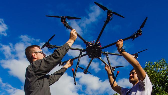 Professor and student launching an ag drone