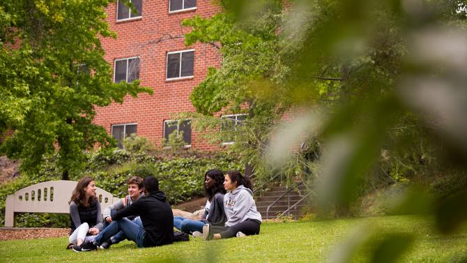 Students sitting in front of dorms