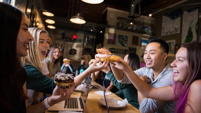 Group of students eating donuts