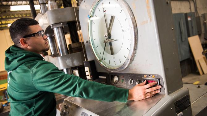 Student working in the seismic lab using a machine that tests the structural impact of earthquakes