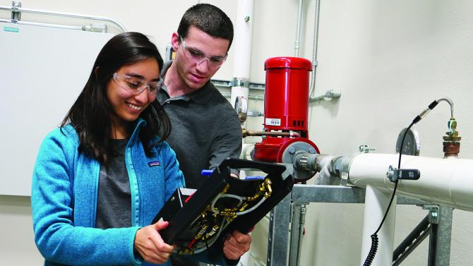 Two engineering students studying water pipes