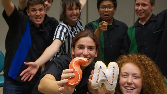 Smile and Nod comedians holding up S & N donuts