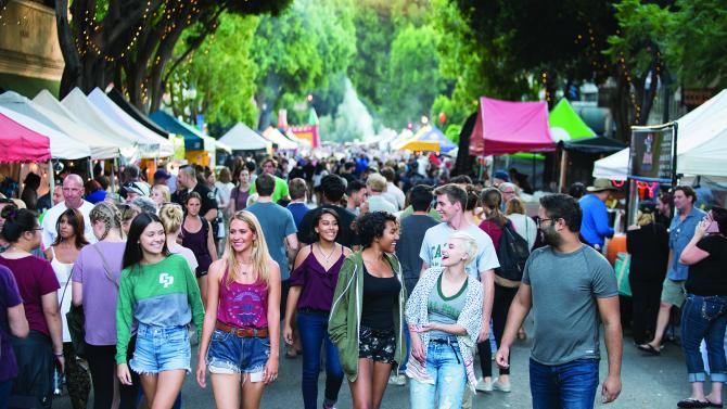 Group of students walking down the street during SLO's Thursday night Farmer's Market