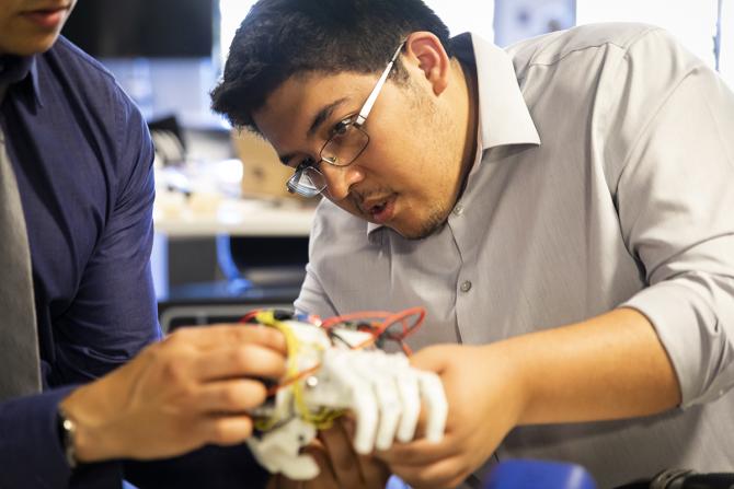 Student works on a prosthetic hand for a child.