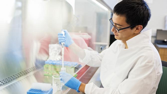 Biochemistry student works with test tube samples in the lab.