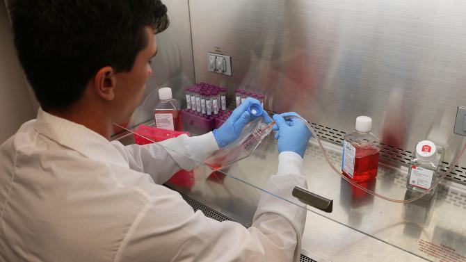 Student in a lab coat works with test tubes in a biomedical engineering lab