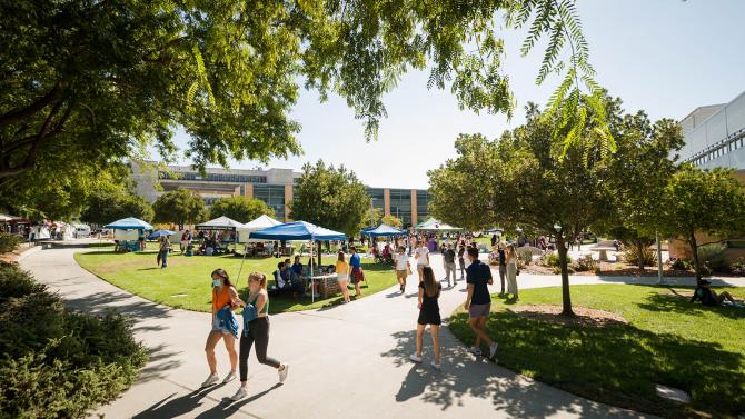 Students walk around a club showcase on Dexter Lawn during the Week of Welcome. 