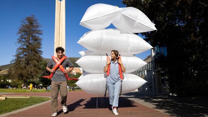 Students carrying materials for their Design Village project